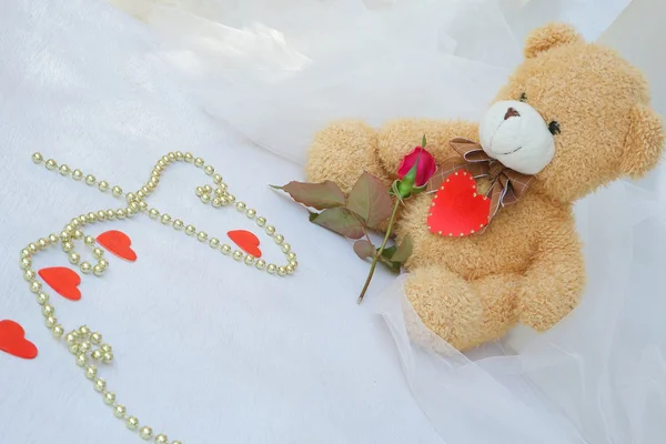 Nallebjörn med rött hjärta och röd ros — Stockfoto