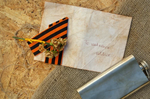 Flores de papel, cinta de San Jorge, frasco de cadera sobre un saco —  Fotos de Stock