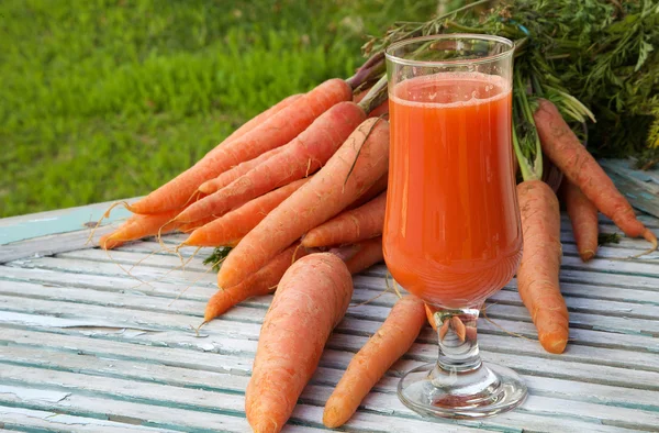 Um copo de suco de cenoura fresca — Fotografia de Stock