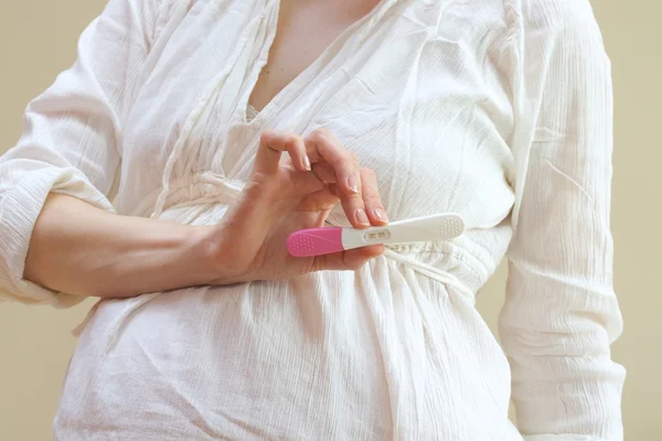 Тест на беременность в руке беременной женщины — стоковое фото
