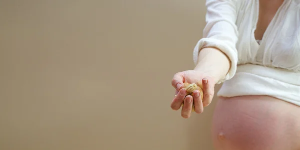 Nueces en la palma de una mujer — Foto de Stock