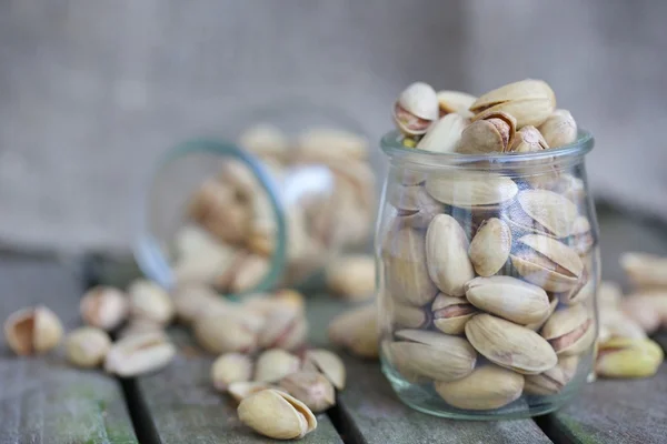 Pistachio nuts in a glass bottle — Stock Photo, Image