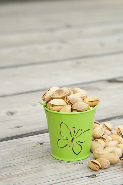 Pistachio nuts on a wooden surface — Stock Photo, Image