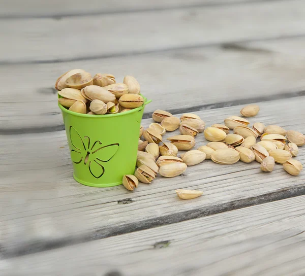 Pistachio nuts on a wooden surface — Stock Photo, Image
