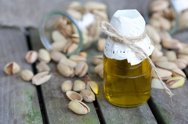 Pistachio nuts oil in a glass bottle — Stock Photo, Image