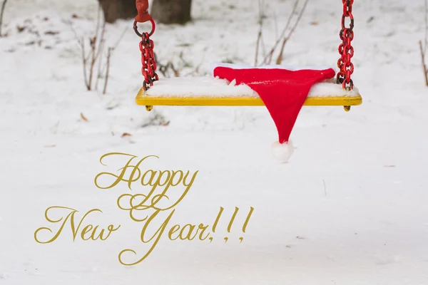 Hat of santa on swing seat — Stock Photo, Image