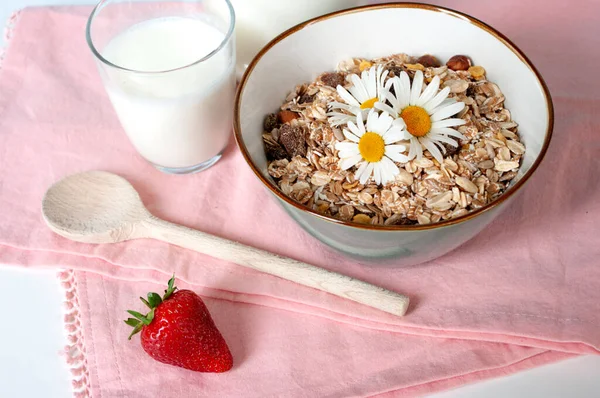 Frühstücksbrei Haferflocken-Müsli in Keramik-Schüssel, auf rosa Teetuch. Glas Milch. — Stockfoto