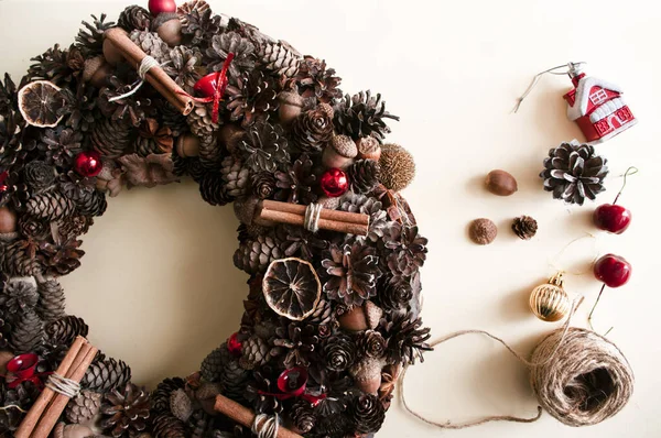 Natural christmas wreath making, from forest harvest and dry fruits. Rustic wreath hand made. Interior decoration. Gift.