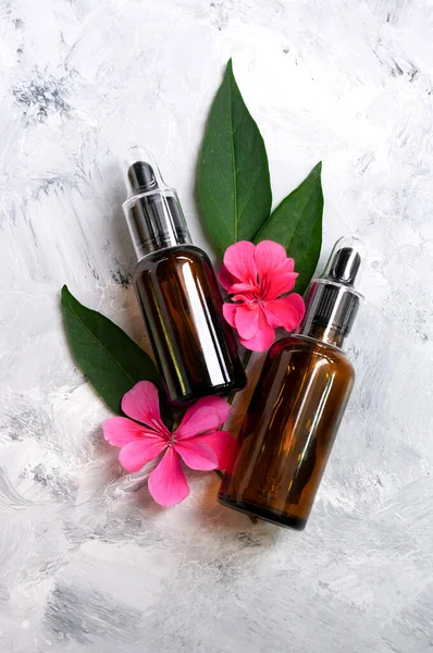 Serum kozmetik, güzellik ürünü, gerekli yağ ve cilt bakımı için iki damlatan şişe. Mermer zemin üzerinde düz kompozisyon. Metin için alanı kopyala. Doğal bakım.