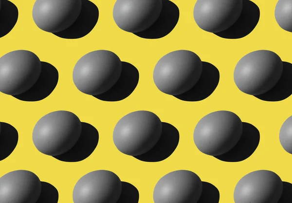 gray Eggs pattern on yellow background. repetitive, duplicate items. easter conception. Colors 2021.