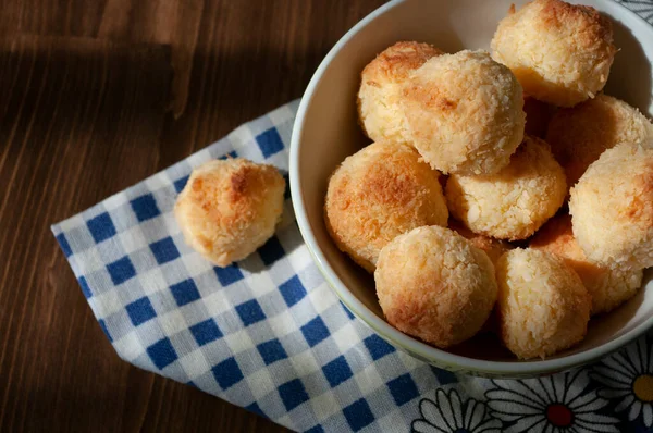 Hindistan cevizli kurabiyeler, seramik kasede, ahşap masada mavi çay havlusuyla. Ev mutfağı fırını.