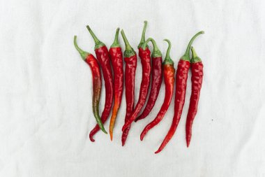 Red hot chili pepper on white cloth background, top view, copy space