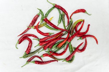 Red hot chili pepper on white cloth background, top view, copy space