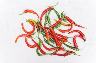 Red hot chili pepper on white cloth background, top view, copy space