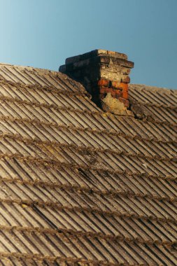 bir evin eski kırsal çatısı, karoların dokusu ve buzdaki bacalar