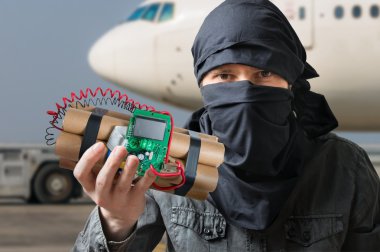 Terörizm kavramı. Terörist havaalanında dinamit bomba elinde tutan