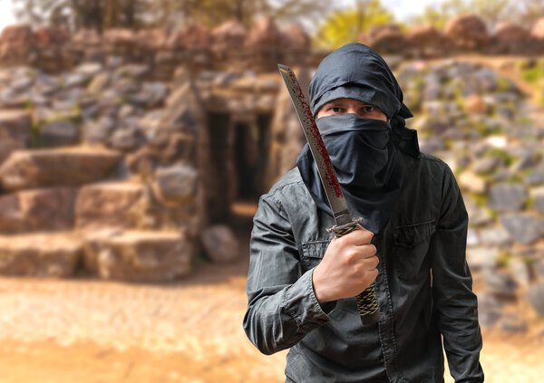 Террорист угрожает кровавым клинком. Концепция терроризма
.