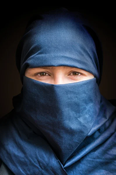 Chef för ung kvinna beslöjade med blå niqab halsduk. Låga nyckelbild. — Stockfoto