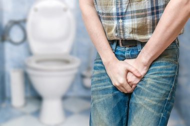 İnkontinans kavramı. Adam işemek istiyor ve onun bladde tutuyor