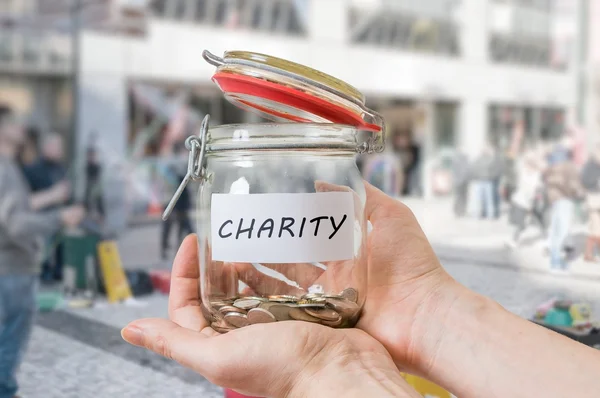 As mãos do voluntário mantêm o jarro com moedas. Recolha de dinheiro para caridade — Fotografia de Stock