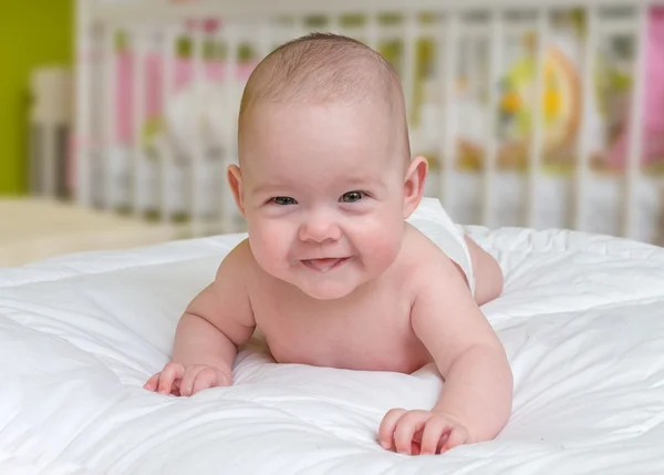 Linda y sonriente niña arrastrándose acostada en el vientre . — Foto de Stock