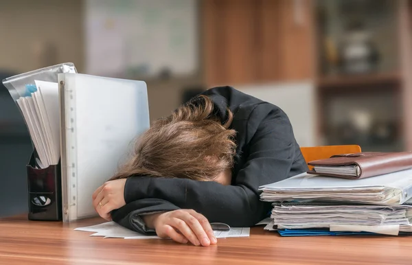 Faule Geschäftsfrau schläft auf Schreibtisch im Büro. — Stockfoto