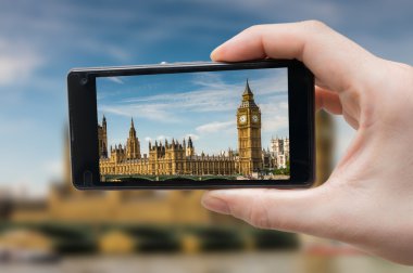 Turist smartphone el ve Londra'da Big Ben fotoğraf çekme tutar