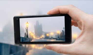 Turist Prag'daki Charles Köprüsü smartphone ile fotoğraf çekimi