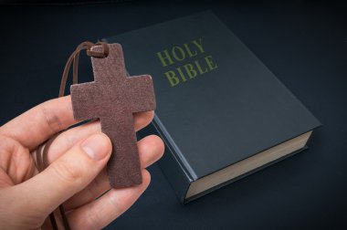 El ahşap çapraz İncil'de yukarıda tutan.