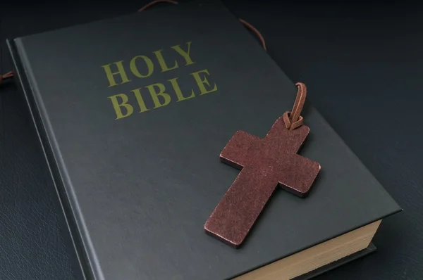 Wooden cross next to Holy Bible. — Stock Photo, Image