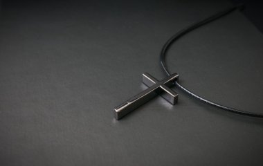 Nechlace siyah arka plan üzerine metalik çarmıhta. Din kavramı