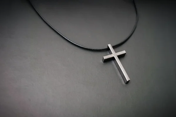 Halsketting met metalen kruis op donkere achtergrond. — Stockfoto