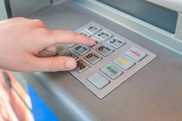 Orang ini menggunakan keypad dan memasukkan pin code di mesin ATM. Konsep perbankan . — Stok Foto