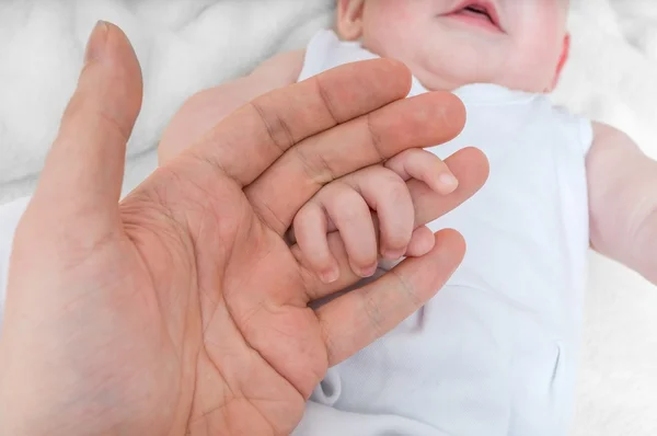 Adoption baby concept. Man holds little child's hand. — Stock Photo, Image