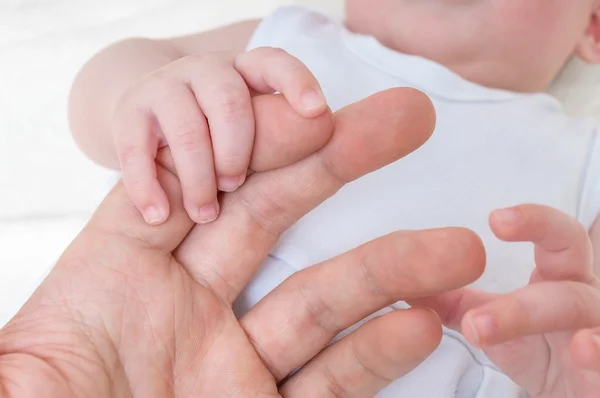 Концепция ухода за новорожденными. Мужчина держит за руку ребенка . — стоковое фото