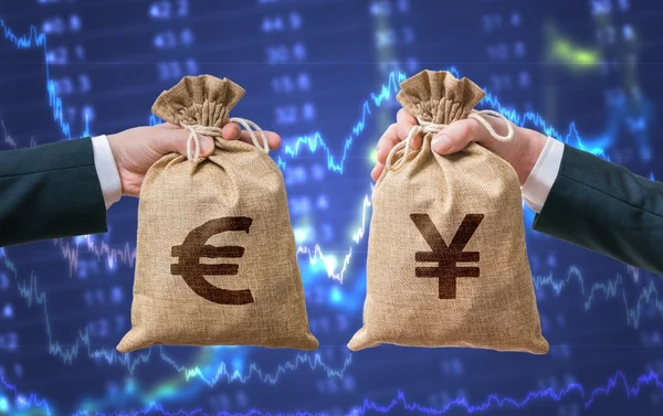 Currency exchange concept. Hands holds bags full of money - Euro and Yen. — Stock Photo, Image