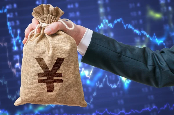 Hand of businessman holds bag full of money with Yen sign. — Stock Photo, Image
