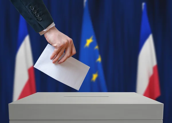 Wybory we Francji. Wyborca posiada kopertę w ręku powyżej głosowania. — Zdjęcie stockowe