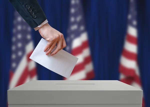 Elecciones en los Estados Unidos de América. Votante sostiene sobre en mano sobre papeleta de votación . — Foto de Stock