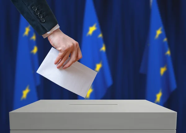 Elecciones en la UE. Votante sostiene sobre en mano sobre papeleta de votación . — Foto de Stock