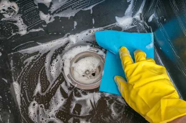 Housework concept. Person is cleaning granite sink in kitchen with rag. — Stock Photo, Image