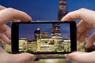 Turist fotoğraf Londra gece smartphone ile atıyor.