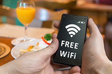 Adam restoranda smartphone ile ücretsiz Wi-Fi kullanarak.