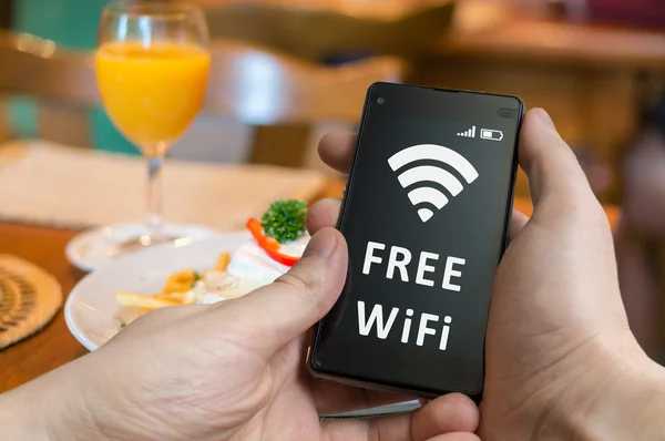 남자는 스마트폰으로 레스토랑에서 무료 와이파이 사용 하는. — 스톡 사진