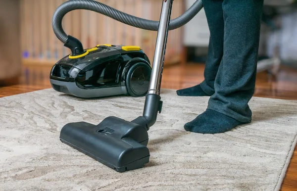 Manusia membersihkan karpet dengan vacuum cleaner . — Stok Foto