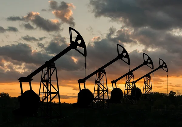 Muchas siluetas de perforación de plataformas petrolíferas al atardecer . —  Fotos de Stock