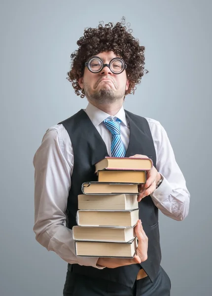 Funny freak nerd professor holds many books in hands.