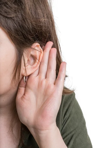 Mujer sostiene su mano cerca de la oreja y escucha cuidadosamente . — Foto de Stock