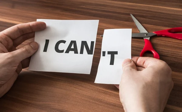 Possibilidade, motivação e conceito de incentivo. O homem está cortando papel com Can 't written . — Fotografia de Stock