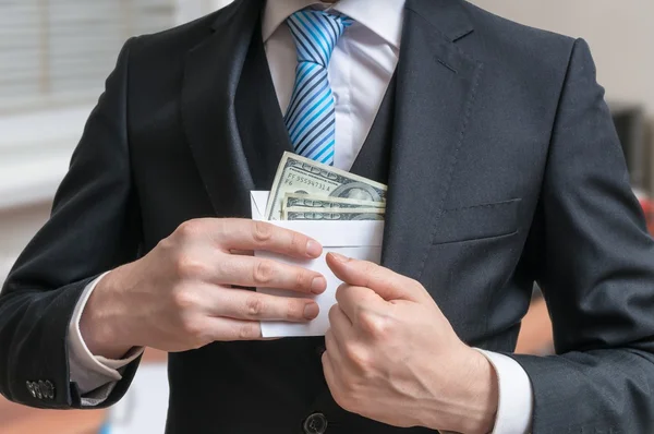 Corruptie concept. Zakenman is het verbergen van brief vol geld of smeergeld in pak jasje. — Stockfoto